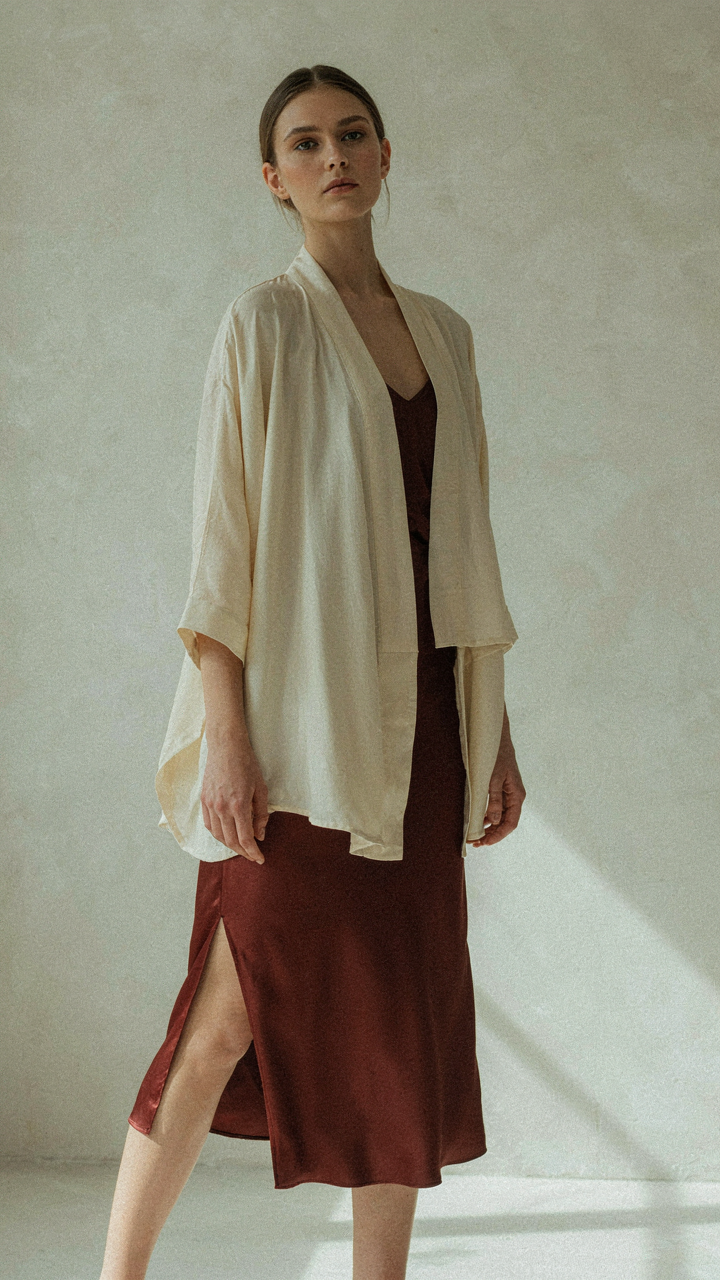 A long kimono jacket with three-quarter sleeves over a sleeveless dress.