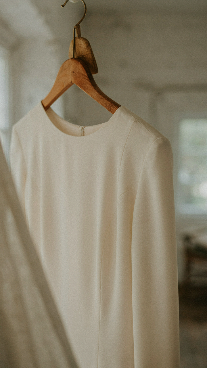 A close-up of a long-sleeved dress with a structured shoulder design.