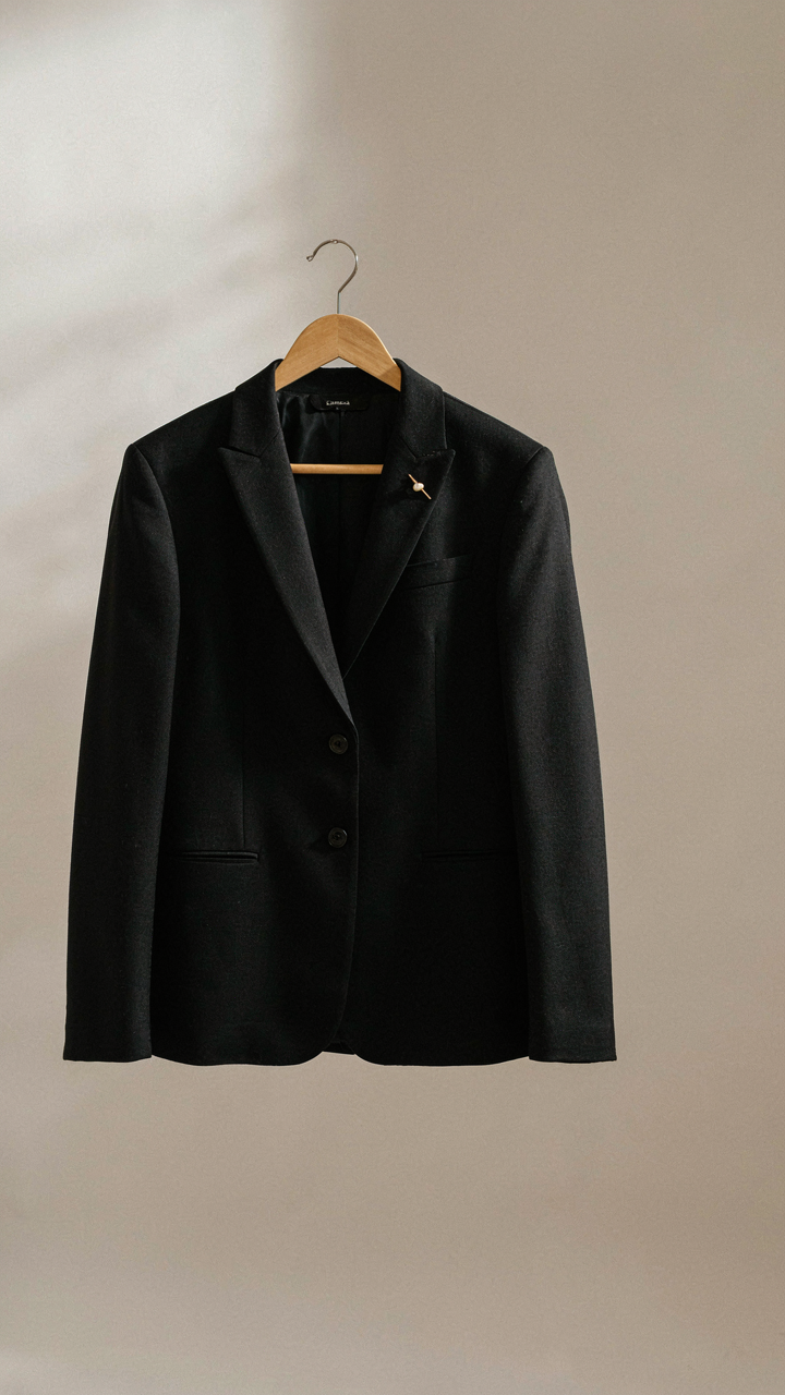 A perfectly tailored black blazer with a single, elegant brooch as the only accessory.