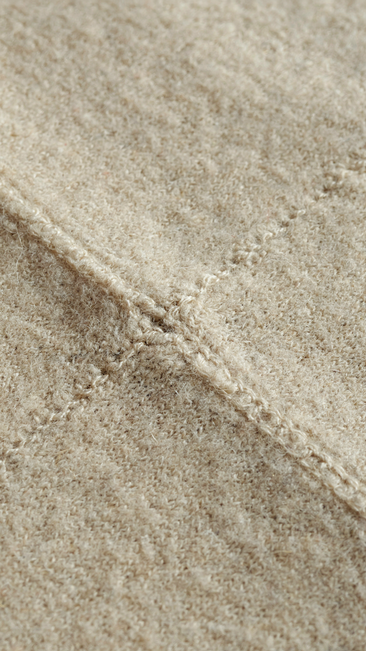 Close-up of high-quality merino wool fabric with flat-lock seams.