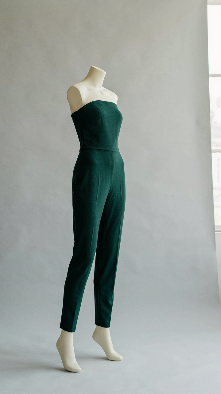 A perfectly fitted strapless jumpsuit on a mannequin, showcasing precise tailoring.