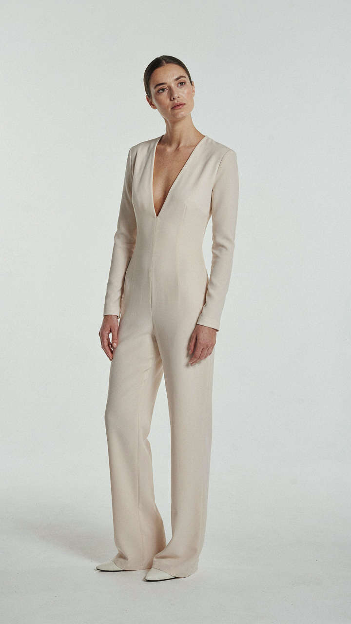A long-sleeved jumpsuit with a deep V-neckline on a white background.
