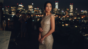 A woman in a shimmering new years eve cocktail dress at a rooftop party.