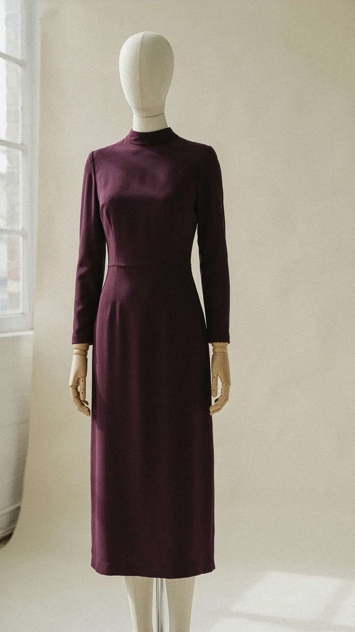 A long sleeve wedding guest dress with a high neckline and knee-length hem.