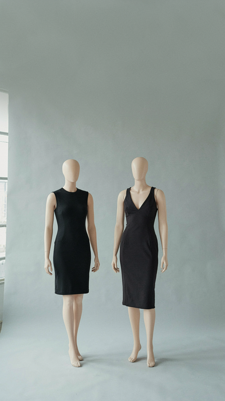 A short bodycon dress and a V-neck pencil dress on mannequins.