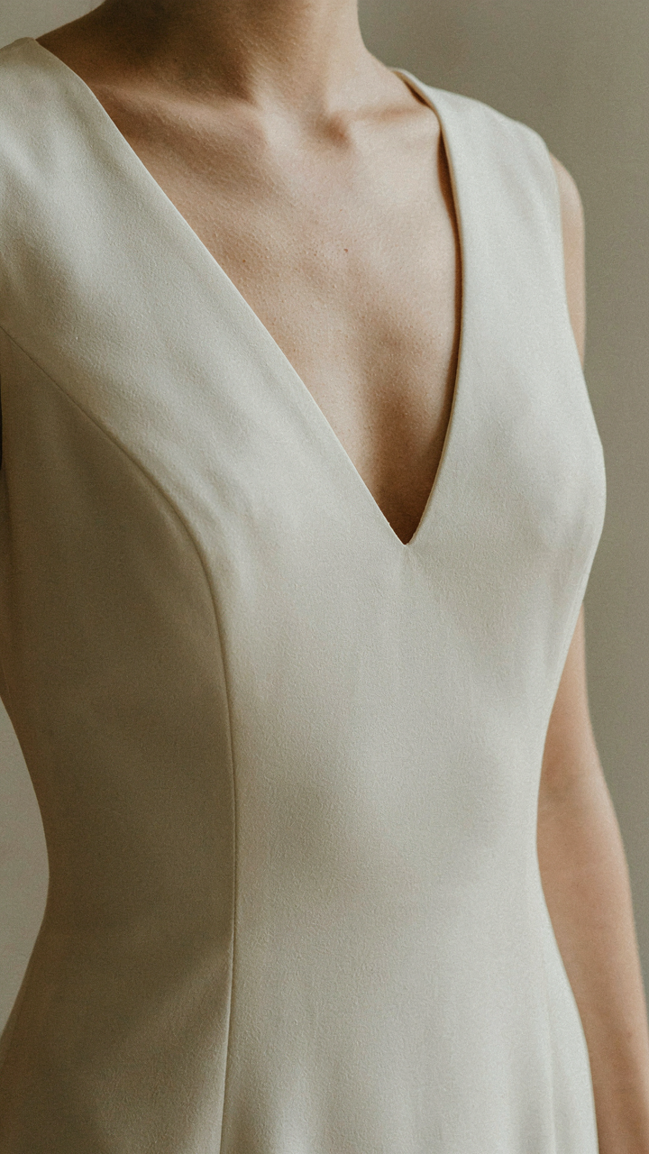 A close-up of an elegant V-neckline dress on a mannequin.