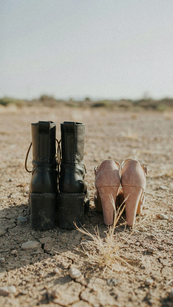 Military boots and wedges stand firmly on rough ground, showing wide heels.