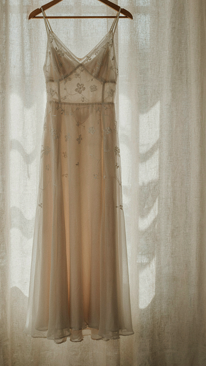 Lightweight nylon slip under a semi-transparent dress on a hanger.