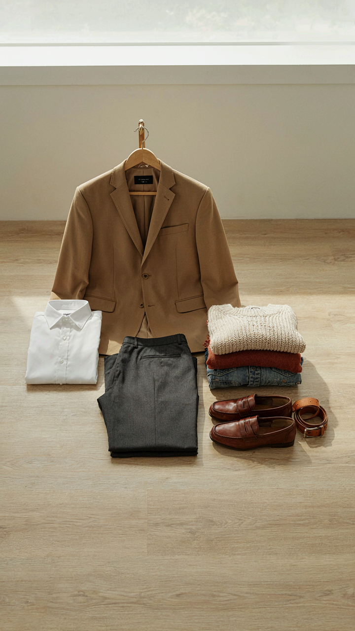 A small, organized wardrobe with a neutral blazer, white shirt, and trousers.