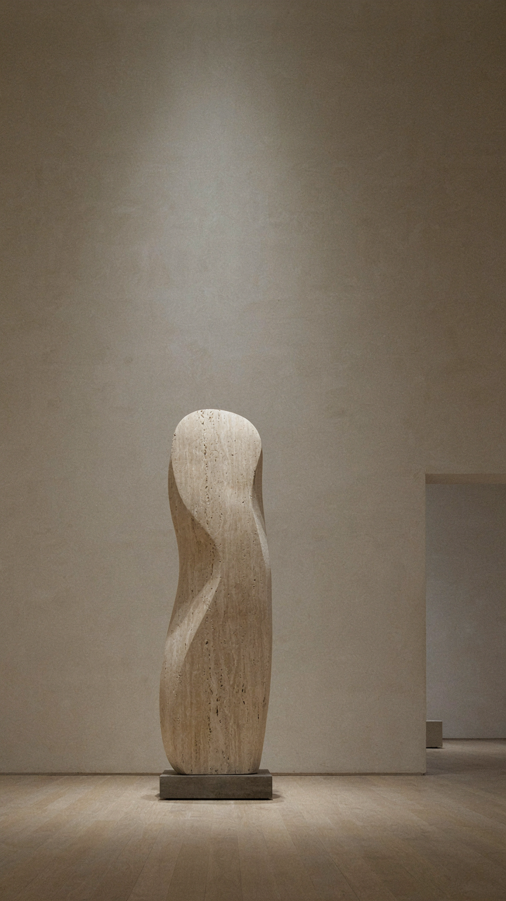 Minimalist art gallery with a single, illuminated sculpture.