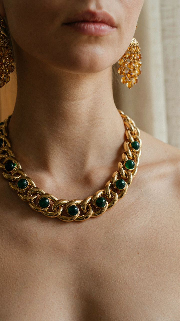 Close up of a woman wearing a bold statement necklace and large chandelier earrings.