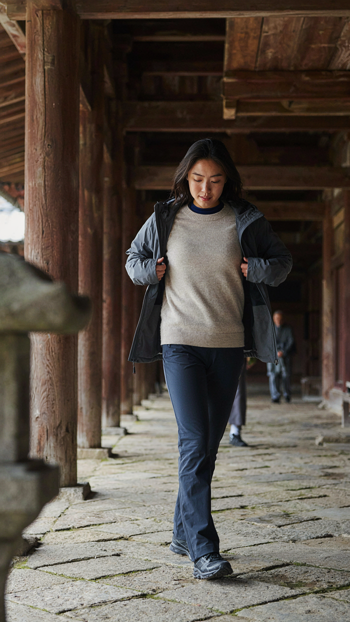 A person takes off a jacket inside a cold temple, showing layers.