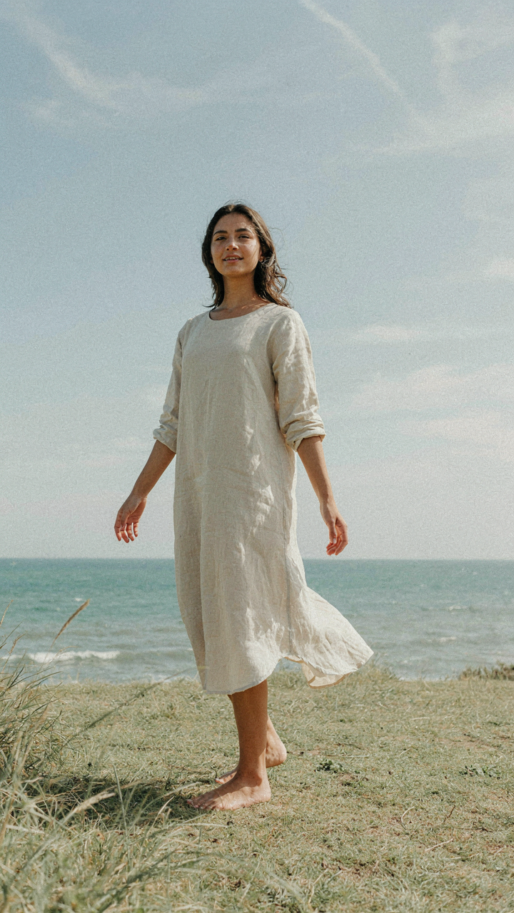 Woman in a loose, flowing A-line maxi dress with air movement.