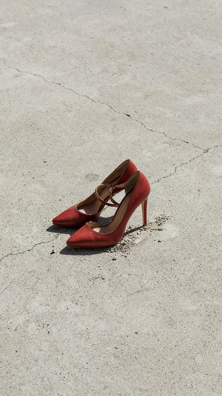 Elegant high heels with a narrow sole on a concrete surface.