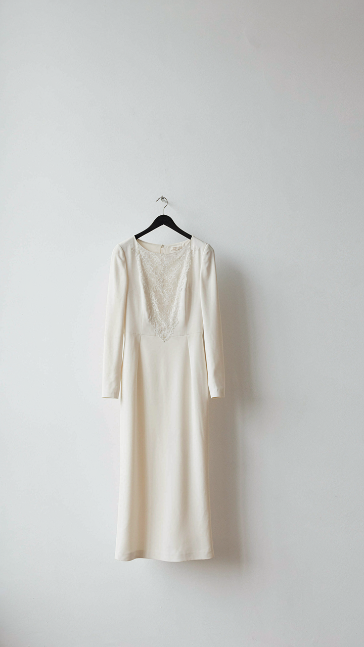 A sleek, tailored dress with a single elegant lace panel on the bodice.