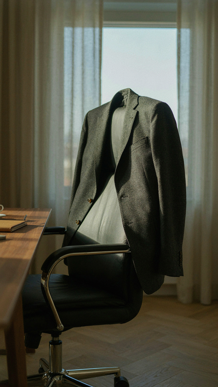A wool blazer draped over an office chair, ready for any event.