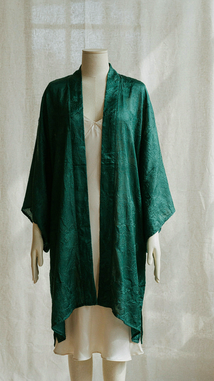 A long kimono jacket draped over a fitted slip dress on a mannequin.