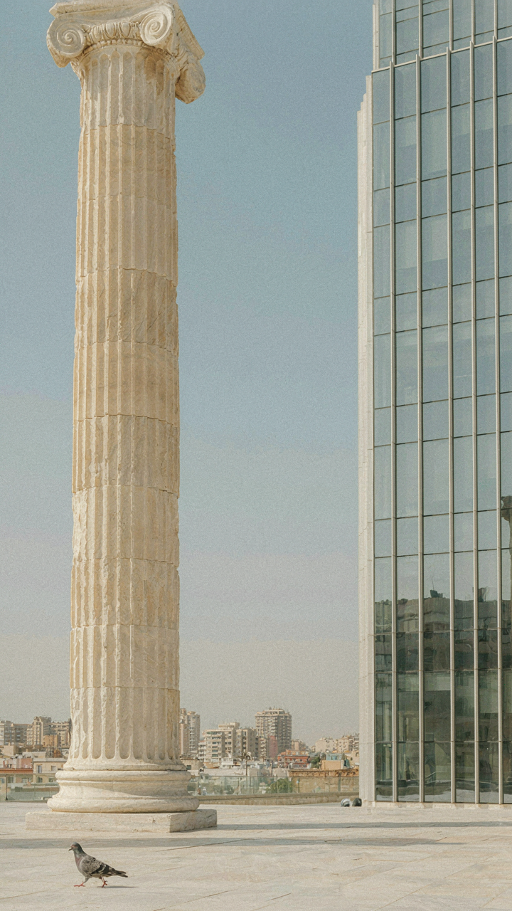 Architectural blueprint showing a classical column and a modern glass tower.