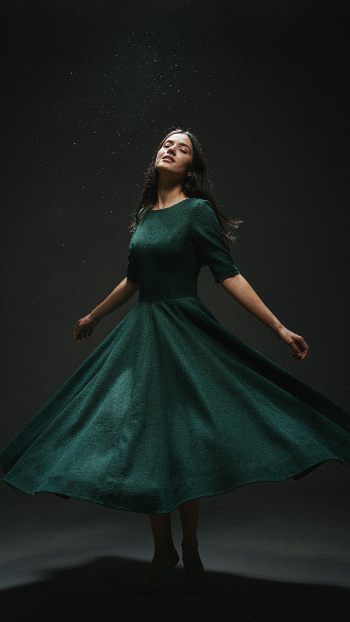 A woman in a wool blend gown dances under strobe lights at a new years eve wedding.