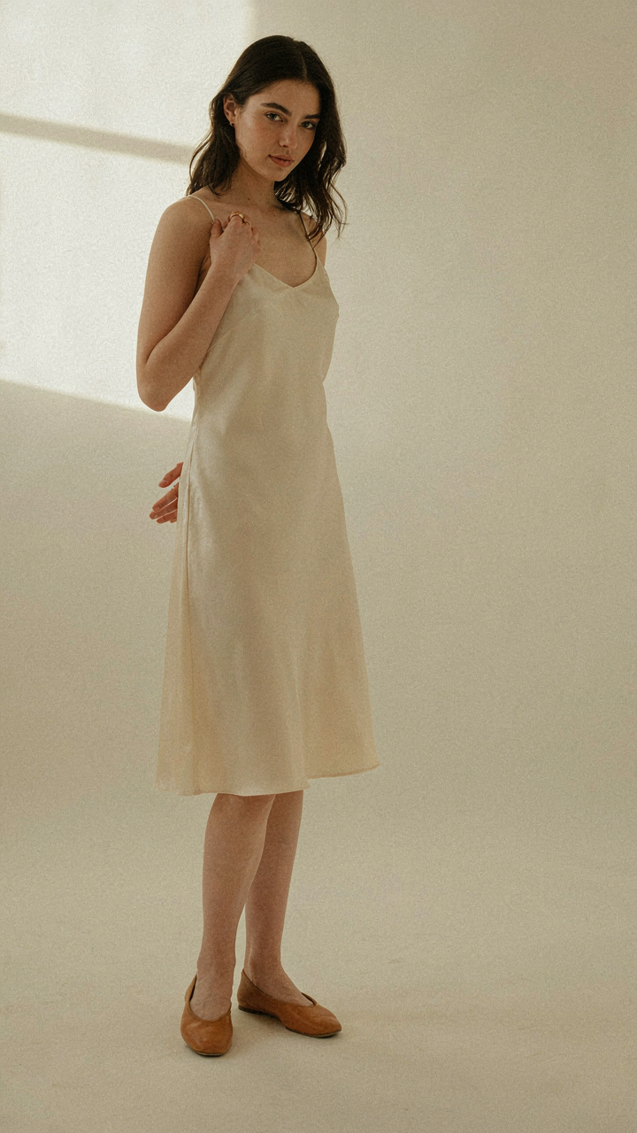 Chic slip dress with a single gold signet ring and minimalist ballet flats.