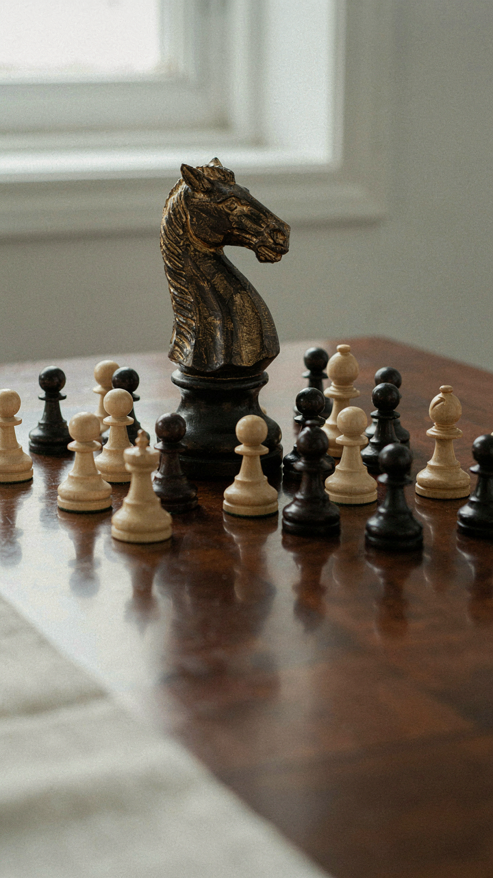 An ornate chess knight stands out among many pawns on a dark wood board.