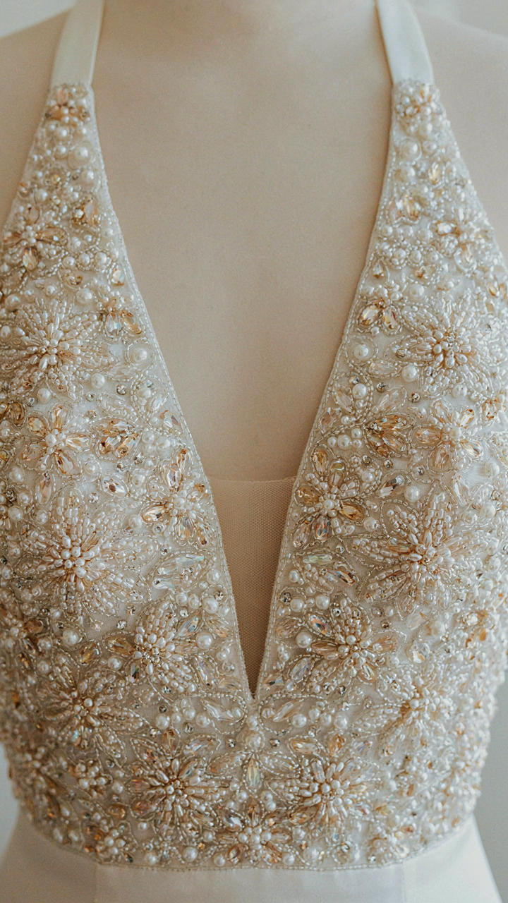 Close-up of a halter cocktail dress bodice with intricate hand-beading.