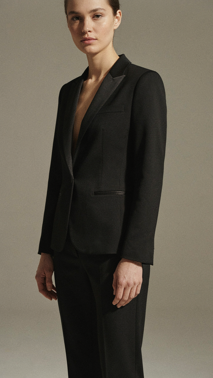 A black formal suit shows the sheen of a silk-wool blend.