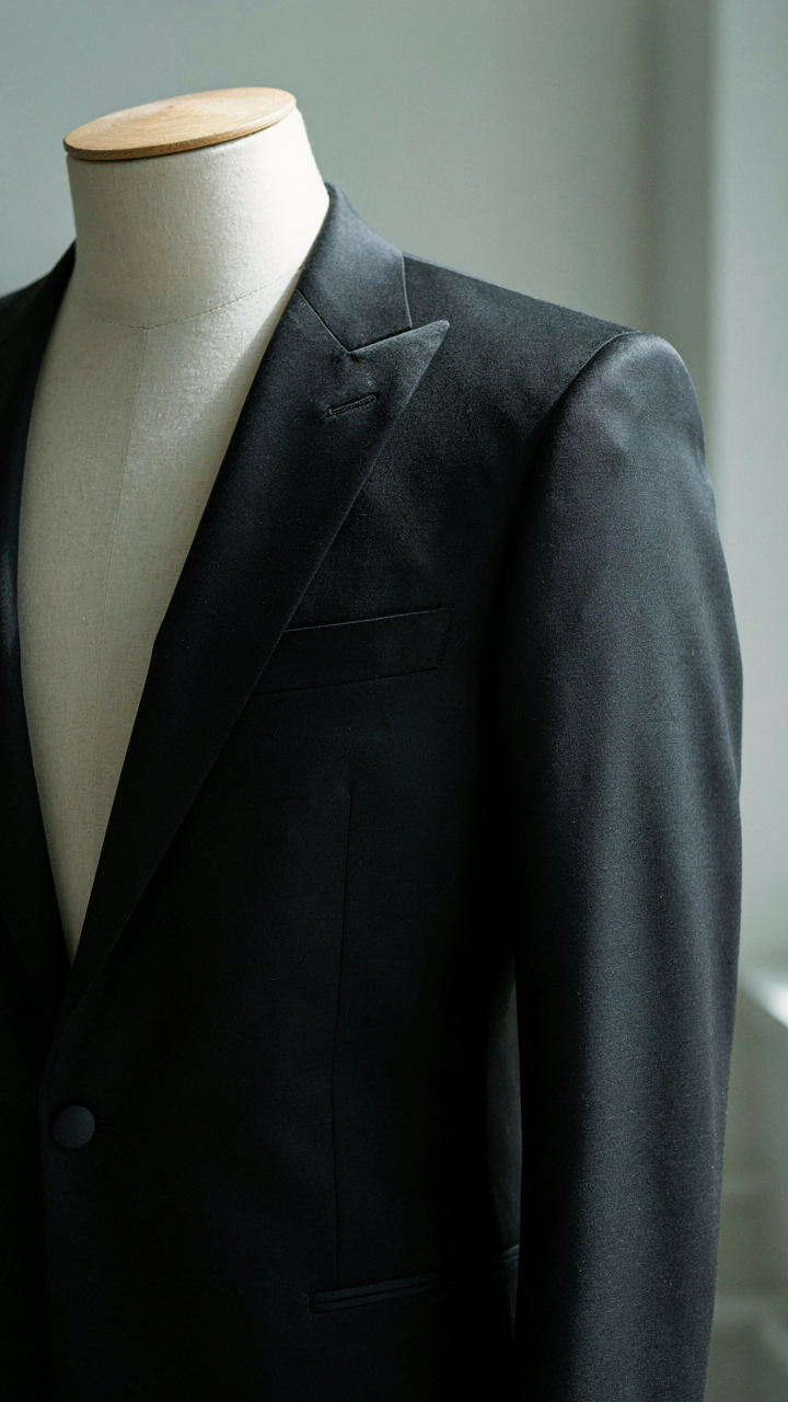 A close-up of a perfectly tailored black tuxedo jacket.