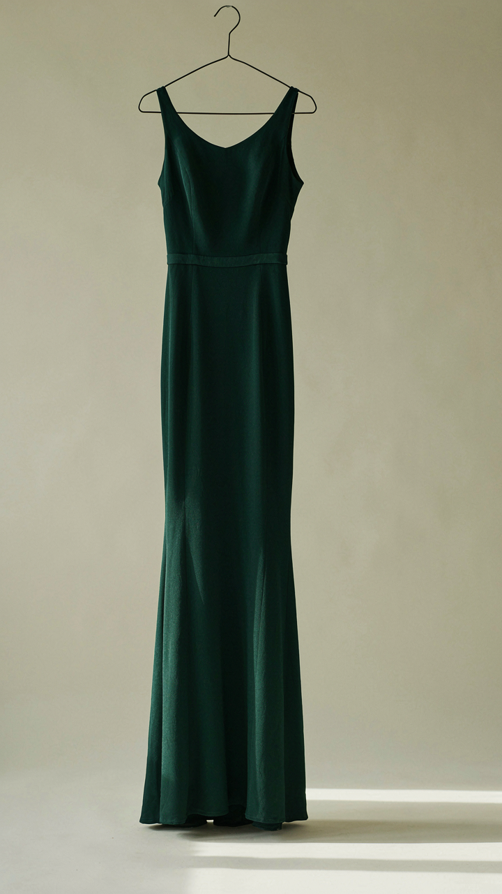 A dark emerald green evening gown with an asymmetrical neckline.
