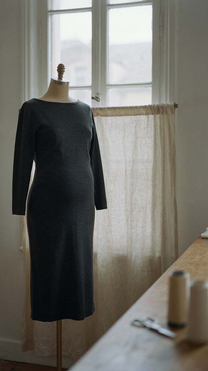 A tailor's dummy shows a well-fitted, structured ponte-knit pregnant wedding guest dress.