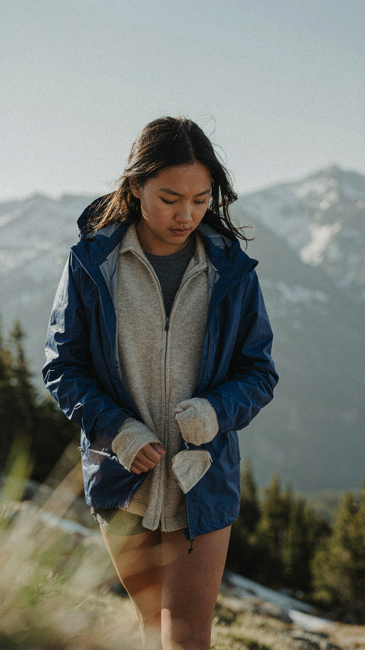 A person removes a jacket to show functional, layered clothing underneath.