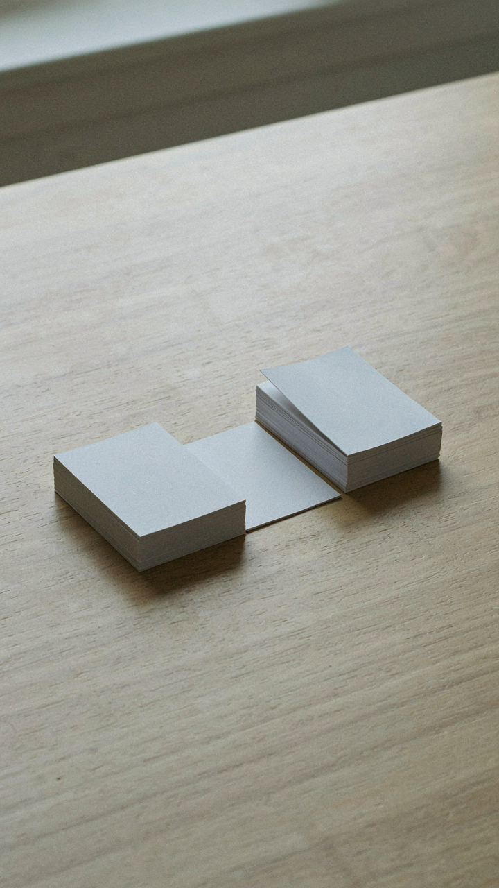A pristine stack of business cards next to one showing slight wear.