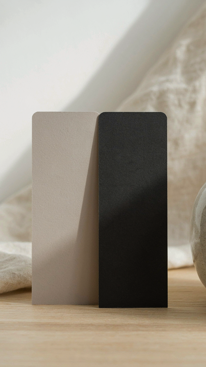 Two paint swatches, muted taupe and rich charcoal, demonstrating color contrast.