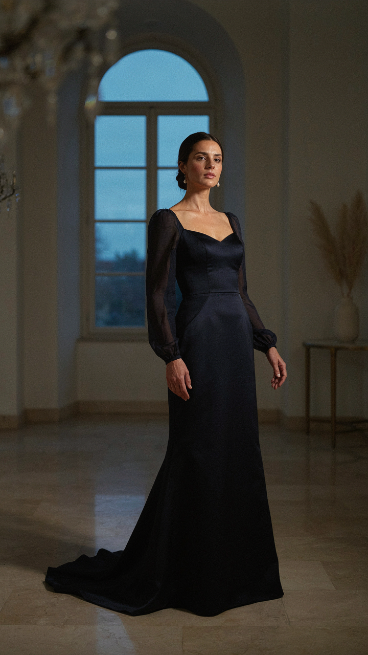 A woman in a fitted evening gown stands with grace and confidence.