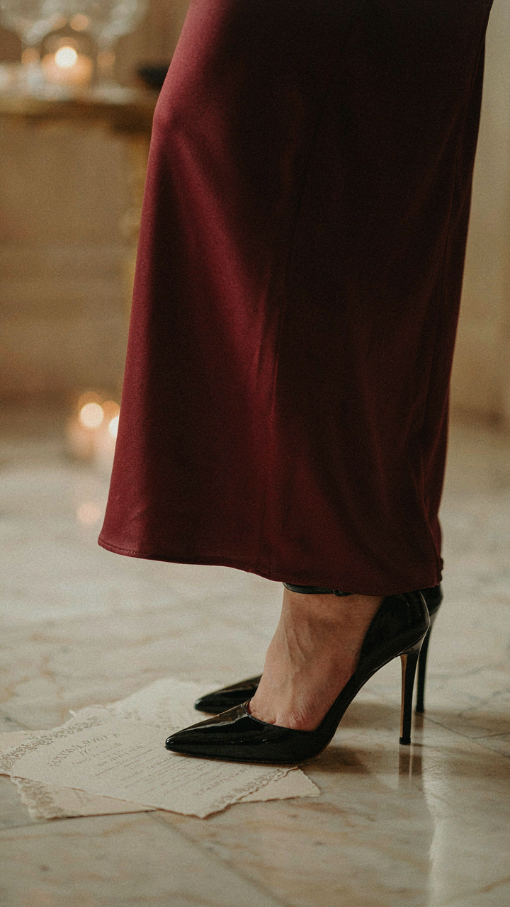 A high-heeled shoe steps on a vague cocktail party invitation.