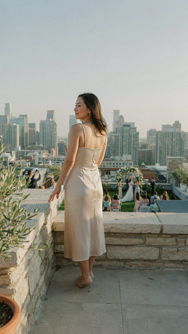 A guest in practical rooftop wedding guest attire comfortably watches a ceremony.