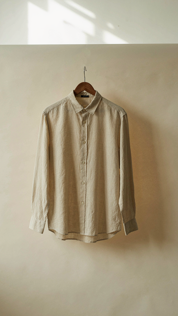 A plain, well-fitted linen shirt hangs neatly on a hanger, symbolizing quiet strength.