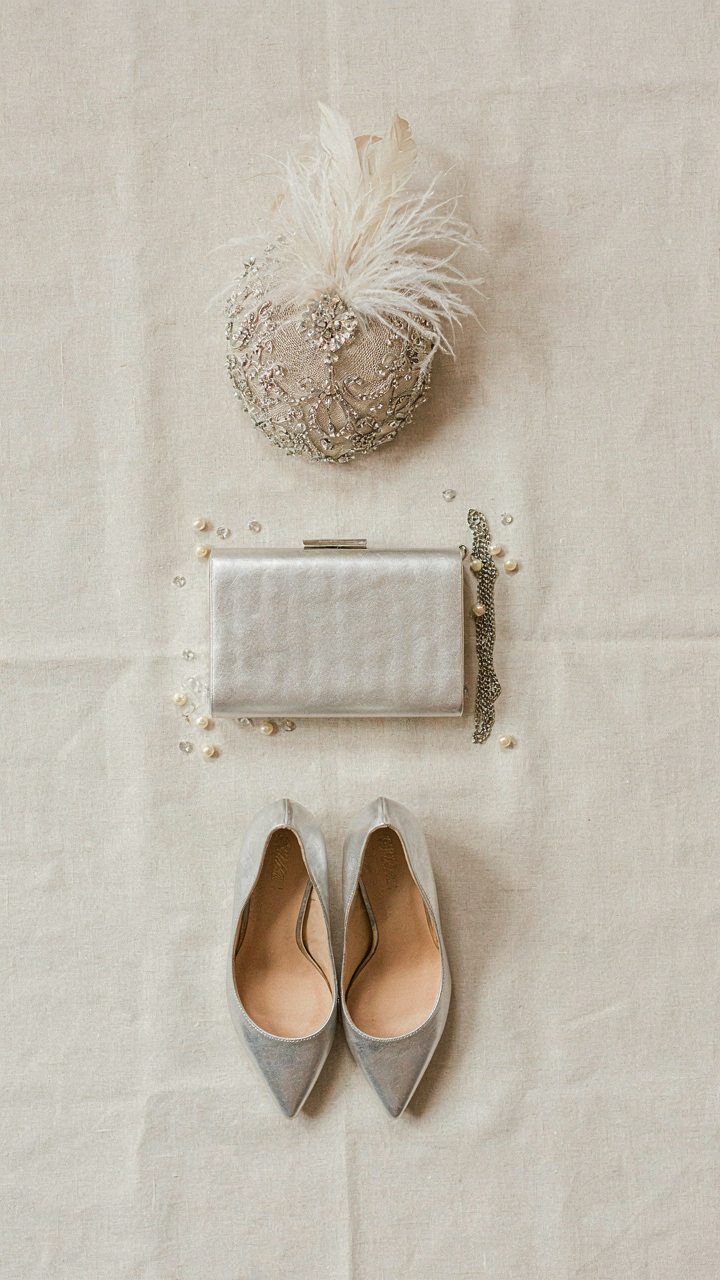 A fascinator with silver hardware, silver shoes, and a silver clutch.