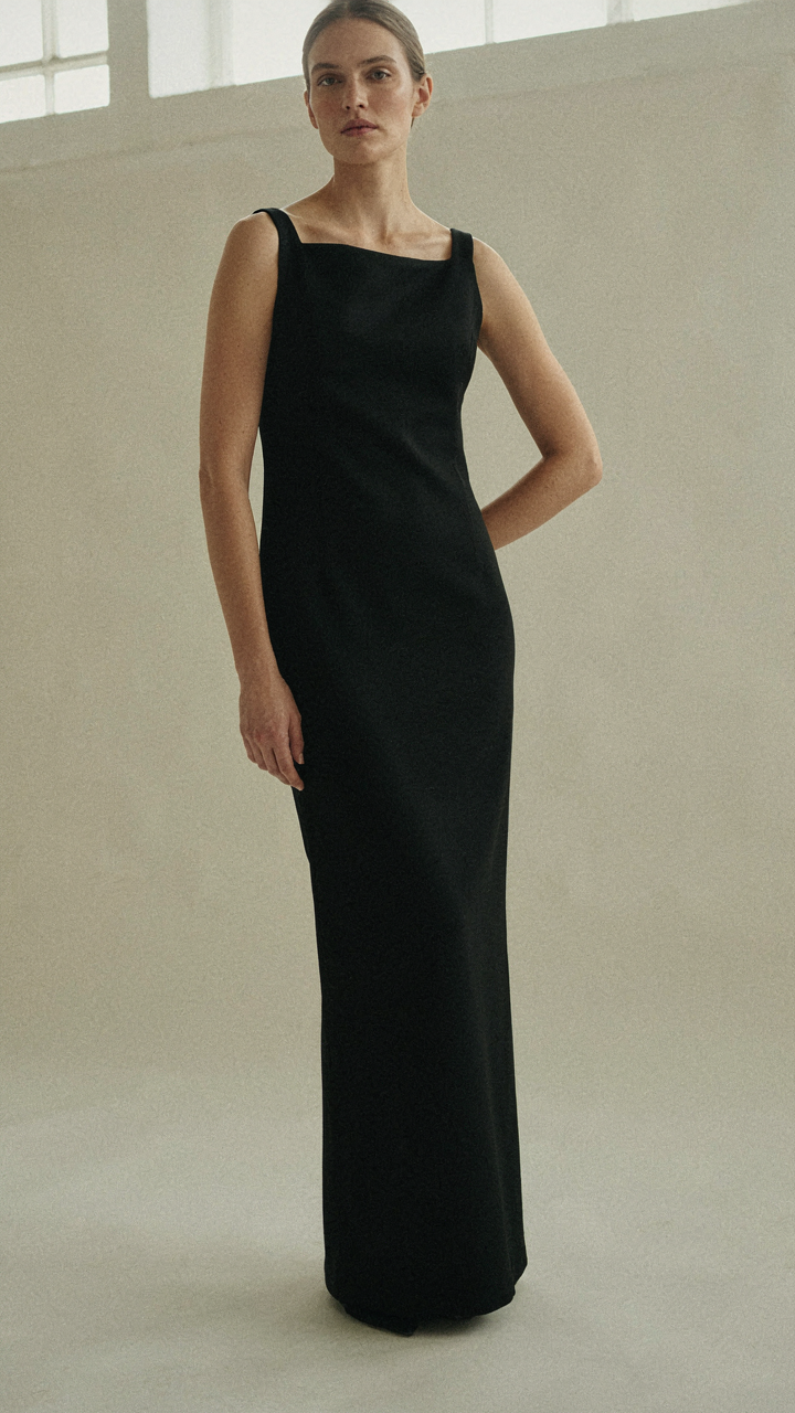 A minimalist black column dress with an asymmetrical neckline.