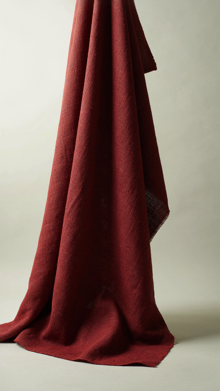 A heavy wool fabric sample is perfectly draped, showing its structure and weight.
