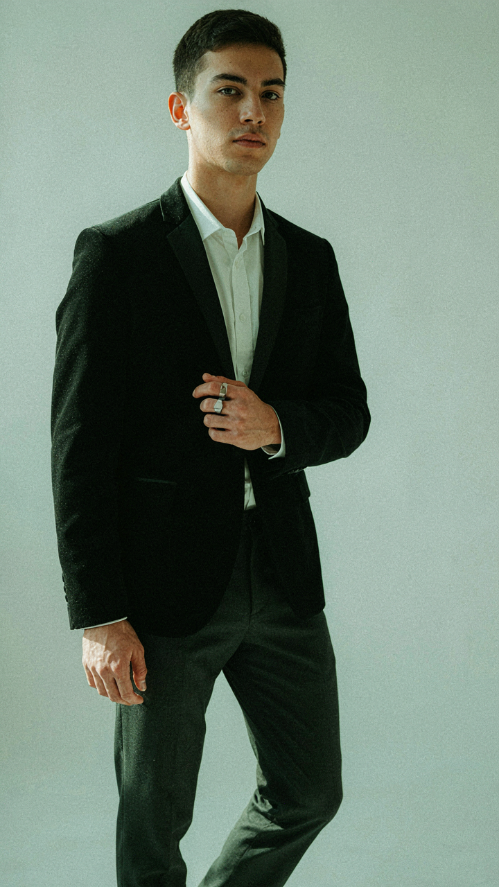 Minimalist outfit featuring a black velvet blazer, white shirt, and dark trousers.