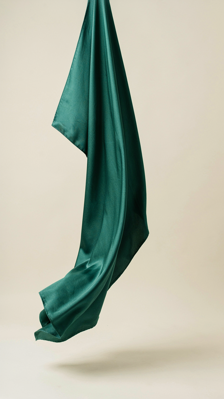 Flowing silk charmeuse fabric draping downwards, showing its fluid movement.