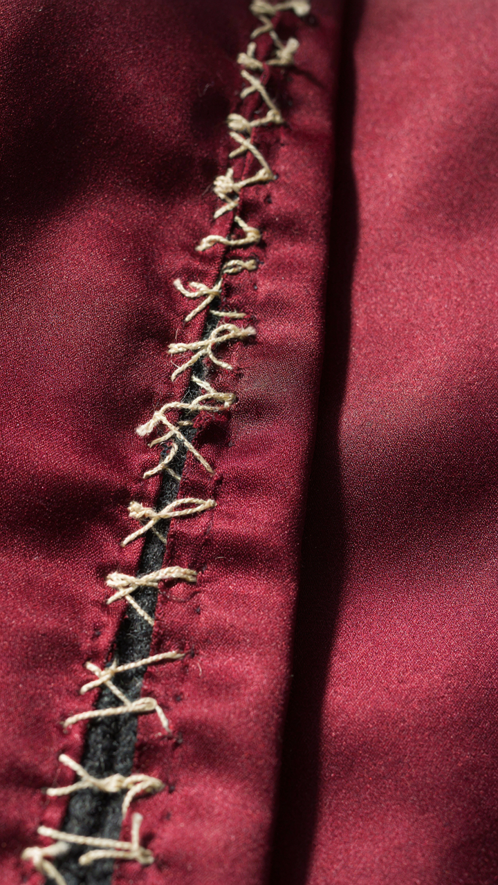 Overlapping hand stitches reinforce a vintage cocktail jacket seam.