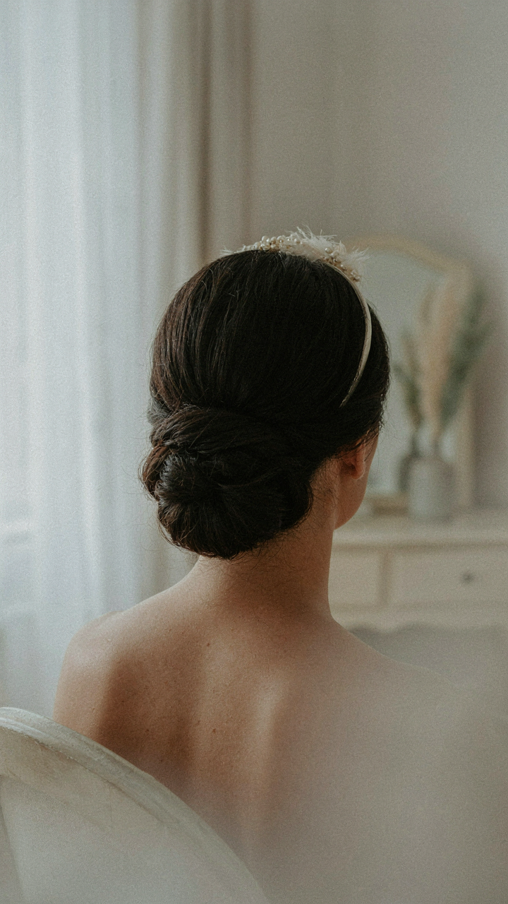 A woman wears a sleek halo headband integrated into a styled updo.