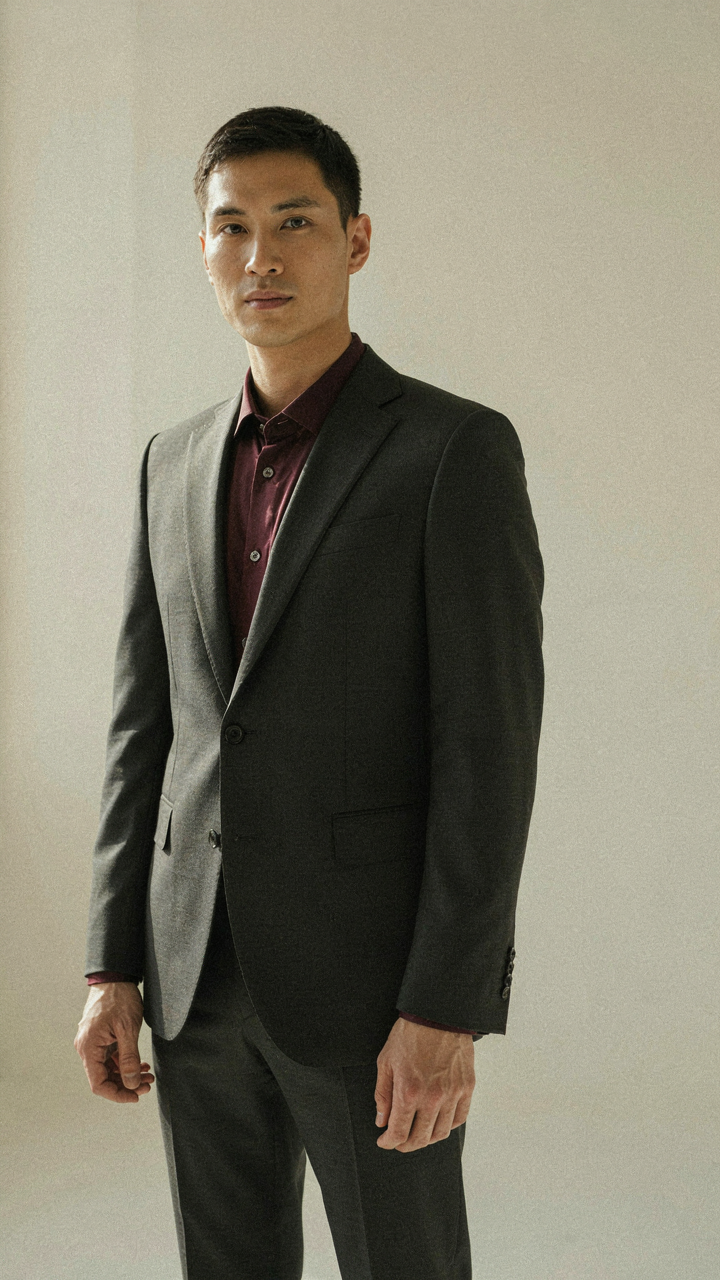 A charcoal blazer with a burgundy silk shirt and metallic cufflinks.