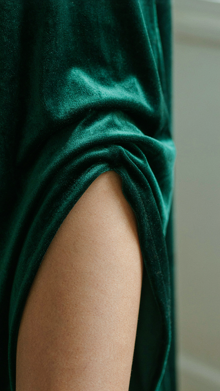 Close-up of velvet fabric subtly creasing where it meets skin on a leg.