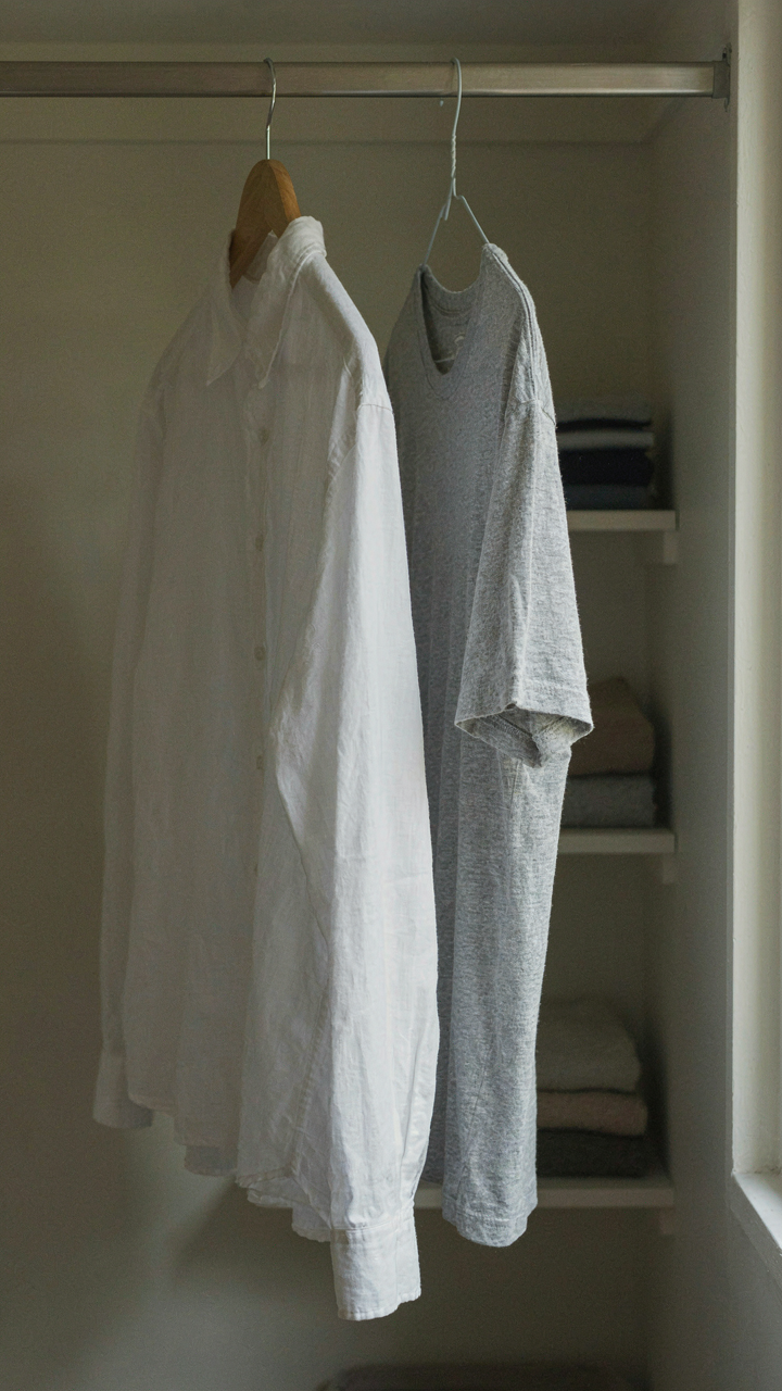A high-quality linen shirt next to a faded, pilled cheap t-shirt in a closet.