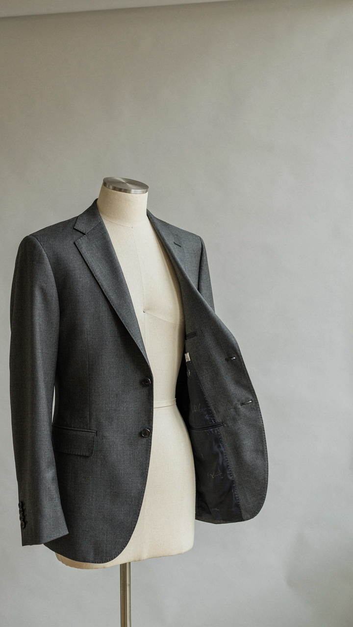 Tailored suit jacket on a mannequin, showing internal structure.