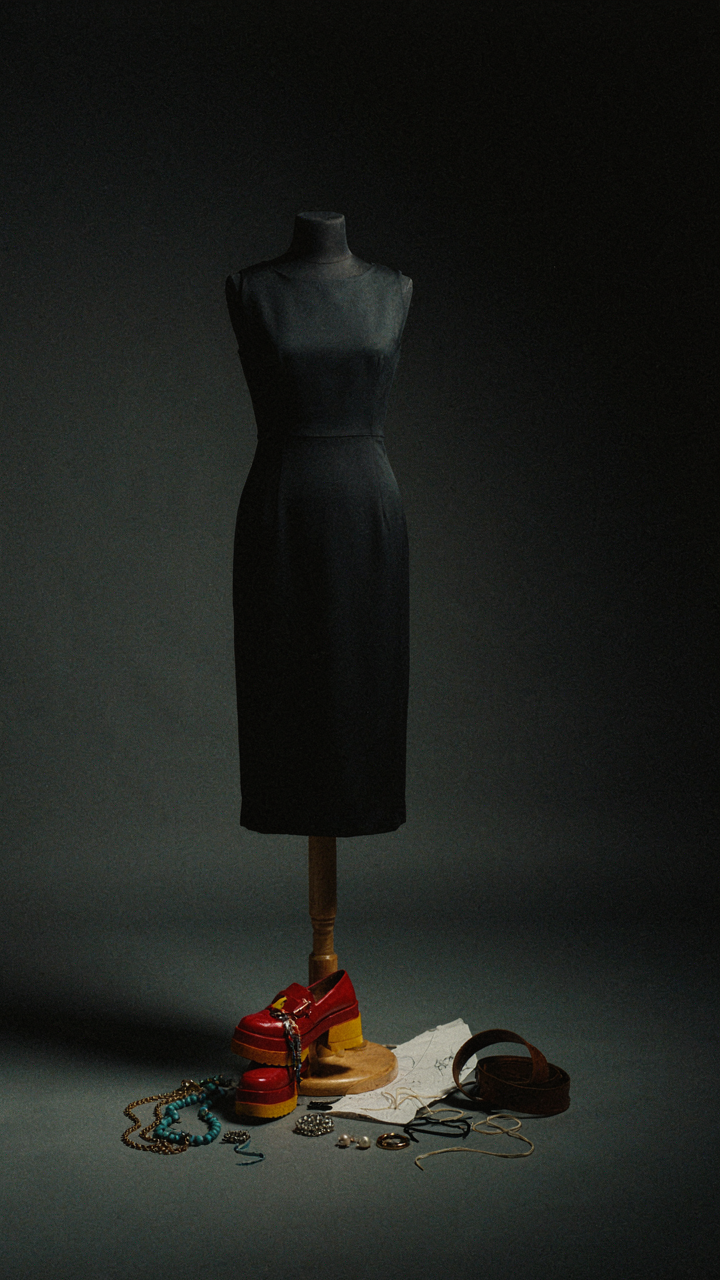 A mannequin with a cocktail dress and discarded, mismatched accessories.