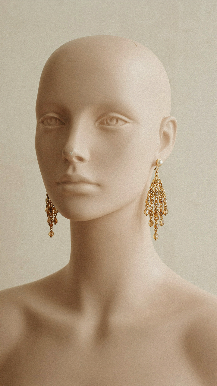Mannequin head with a small stud and a large chandelier earring.